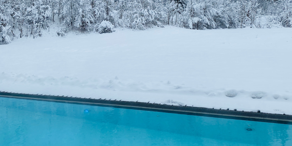 Piscine extérieure entourée de neige, illustrant les coffrets hors-gel Poolplanet, conçus pour protéger la filtration et les équipements de piscine contre le gel et assurer leur bon fonctionnement en hiver.